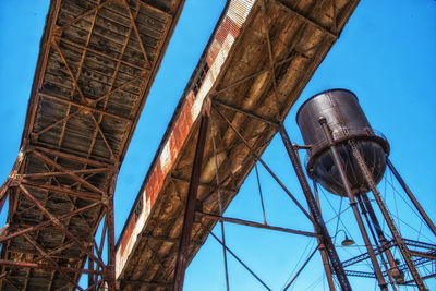 Low angle view of water tower against clear blue sky