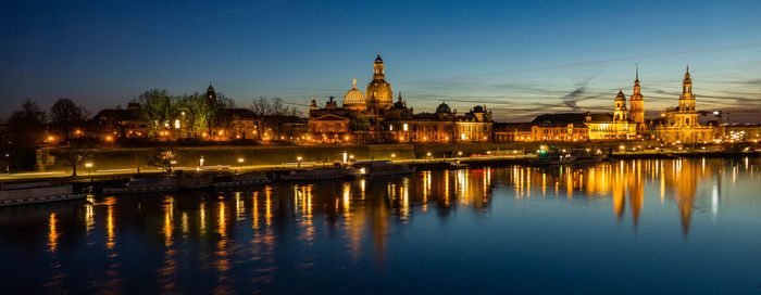 Reflection of illuminated buildings in city at dusk