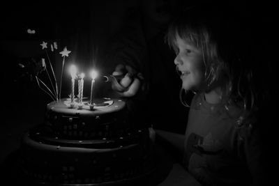 Smiling girl looking at cake during birthday