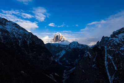 Scenic view of snowcapped mountains against blue sky