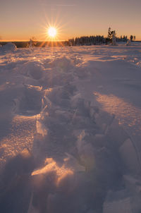 Scenic view of snow covered landscape against sky during sunset