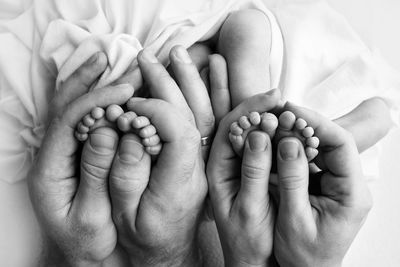 Hand on man holding baby foot