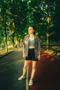 Portrait of young woman standing in park