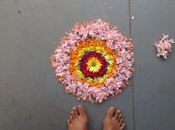 High angle view of flower rangoli and feet