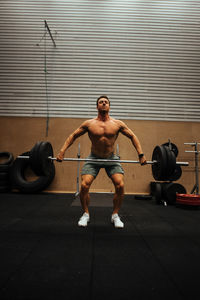 Shirtless man exercising in gym