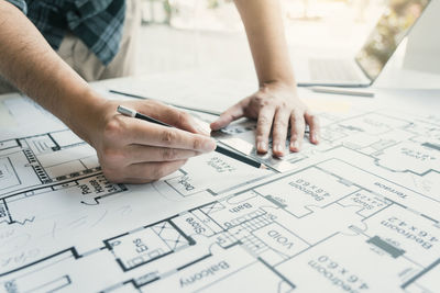 Cropped hands of man working on table