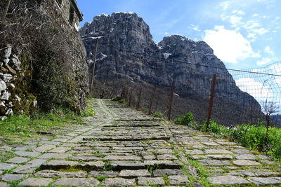 Footpath amidst rocks against sky