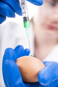 Midsection of scientist injecting egg