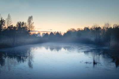 Scenic view of lake against sky during winter