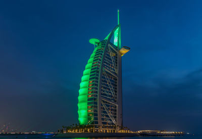 Low angle view of illuminated building against blue sky