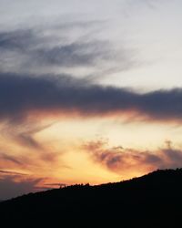 Low angle view of silhouette landscape against dramatic sky