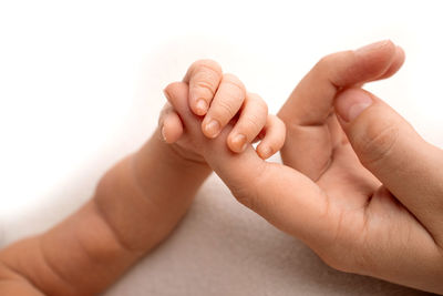 Close-up of baby hand against white background