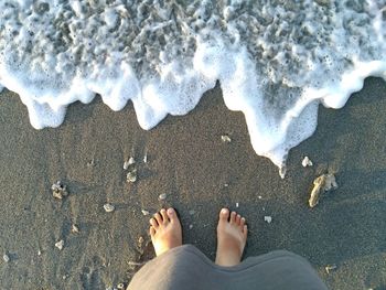 Low section of woman standing on beach