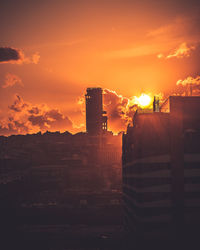 Silhouette buildings against sky during sunset