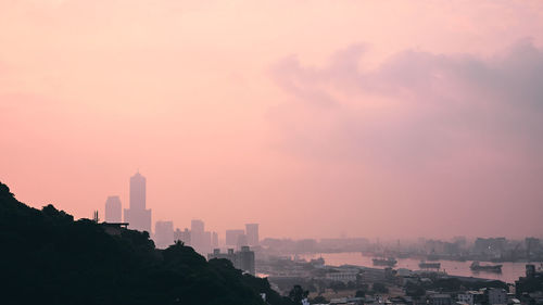 Buildings in city against sky during sunset