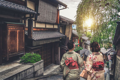 Rear view of people walking on building