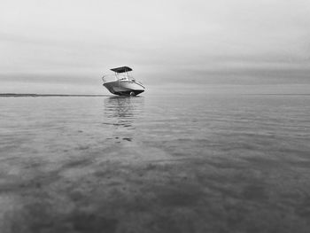 Boat in sea against sky low tide