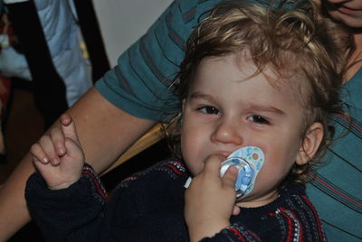 Portrait of cute baby boy with father holding pacifier