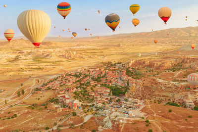 Hot air balloons flying over landscape