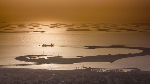 High angle view of sailboats in sea at sunset