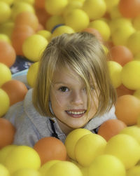 Portrait of girl amidst yellow and orange balloons