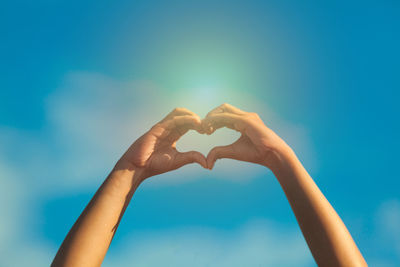 Low angle view of heart shape against blue sky