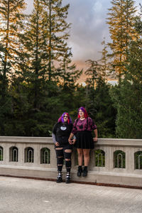 Young women holding hands on bridge