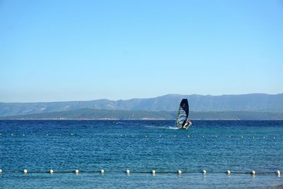 View of calm blue sea against mountain range