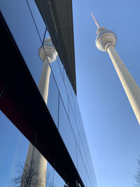 Low angle view of communications tower against blue sky
