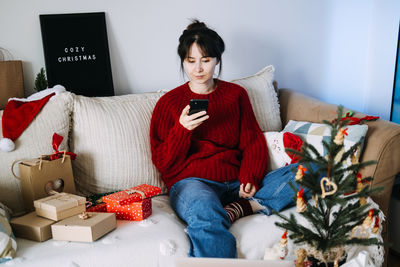 Portrait of young woman sitting on sofa at home