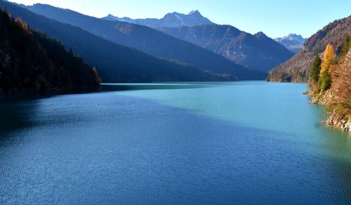 Scenic view of lake by mountains against sky