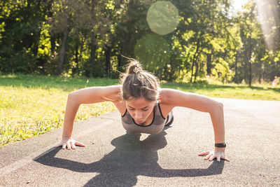 Side view of woman exercising on field