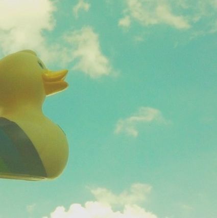 sky, low angle view, mid-air, cloud - sky, blue, flying, yellow, cloud, part of, nature, beauty in nature, cropped, outdoors, sunlight, one person, cloudy, day, close-up, balloon