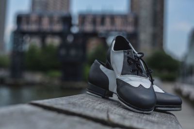 Close-up of shoes on retaining wall in city