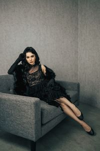 Young woman sitting on sofa at home