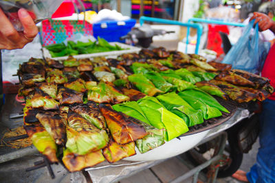 Close-up of man preparing food at market stall