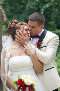 Close-up of couple holding flower bouquet