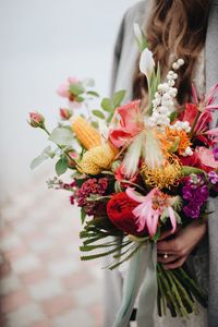 Midsection of woman holding flowers