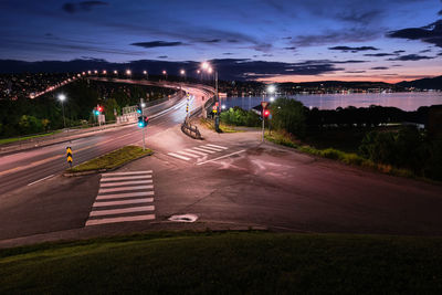 Light trails on road against sky at night