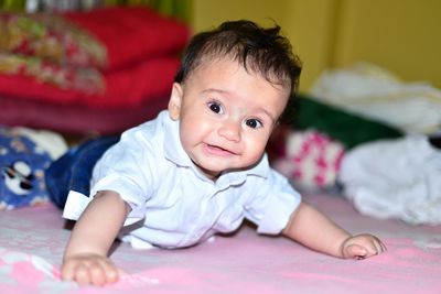 Portrait of cute boy lying on bed at home