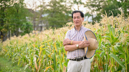 Portrait of young man standing against plants