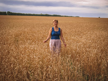 Portrait of standing in farm against sky