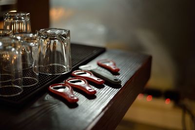 Glasses by bottle openers on wooden table