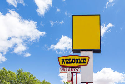 Low angle view of road sign against sky