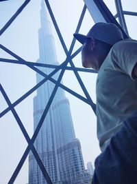 Low angle view of man standing on skyscraper