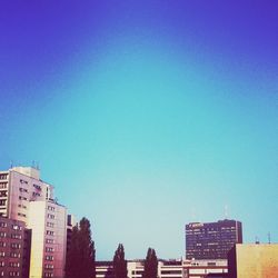 Low angle view of buildings against clear blue sky