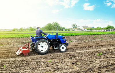 Farmer on a tractor with milling machine loosens, grinds and mixes soil. field preparation 
