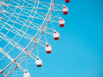 Low angle view of ferris wheel against clear blue sky