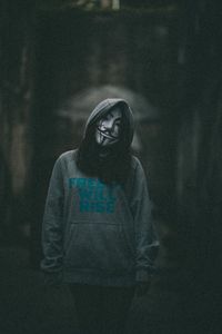 Portrait of a young woman standing against blurred background