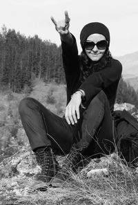 Portrait of smiling young woman sitting on field